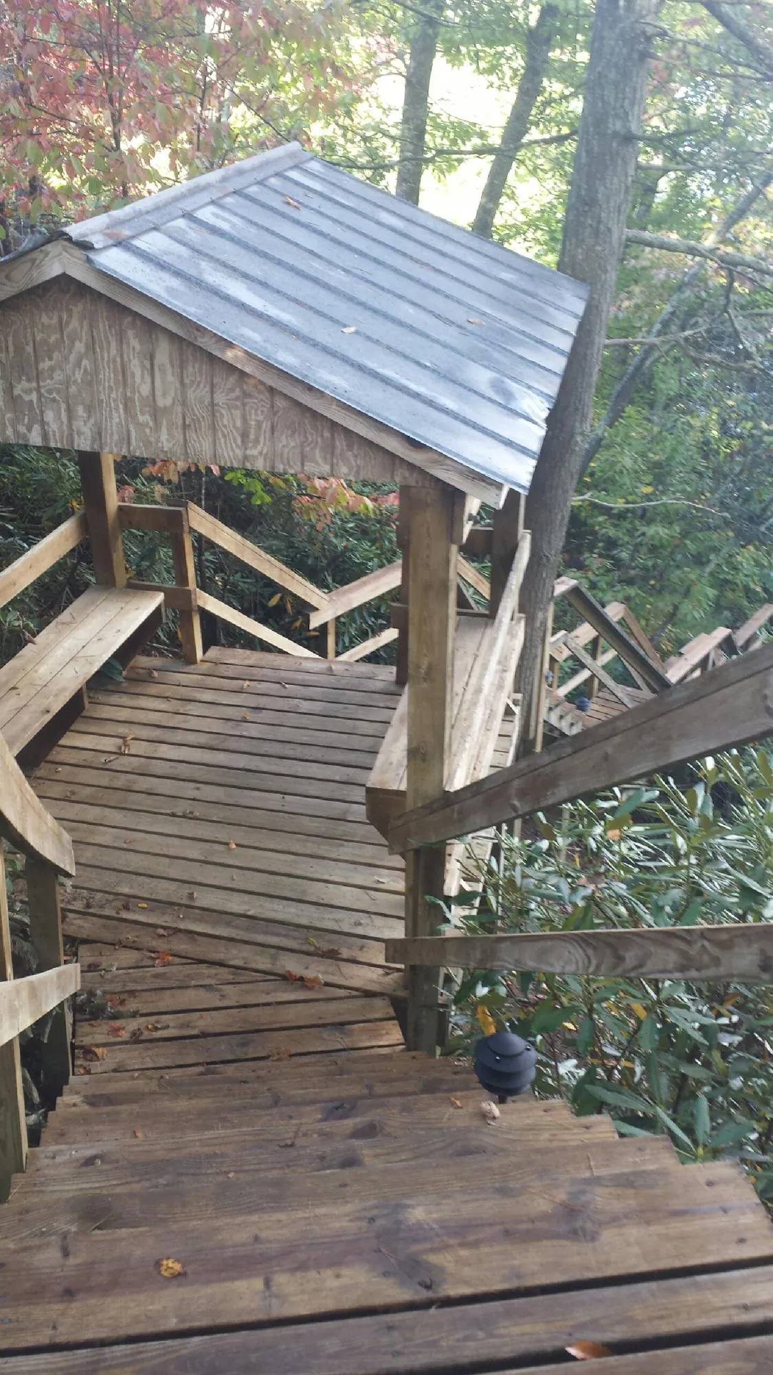 Metal roofed shelter over wooden steps on a wooded walkway — Skylight Repair & Installation work by our crew in Uvalde