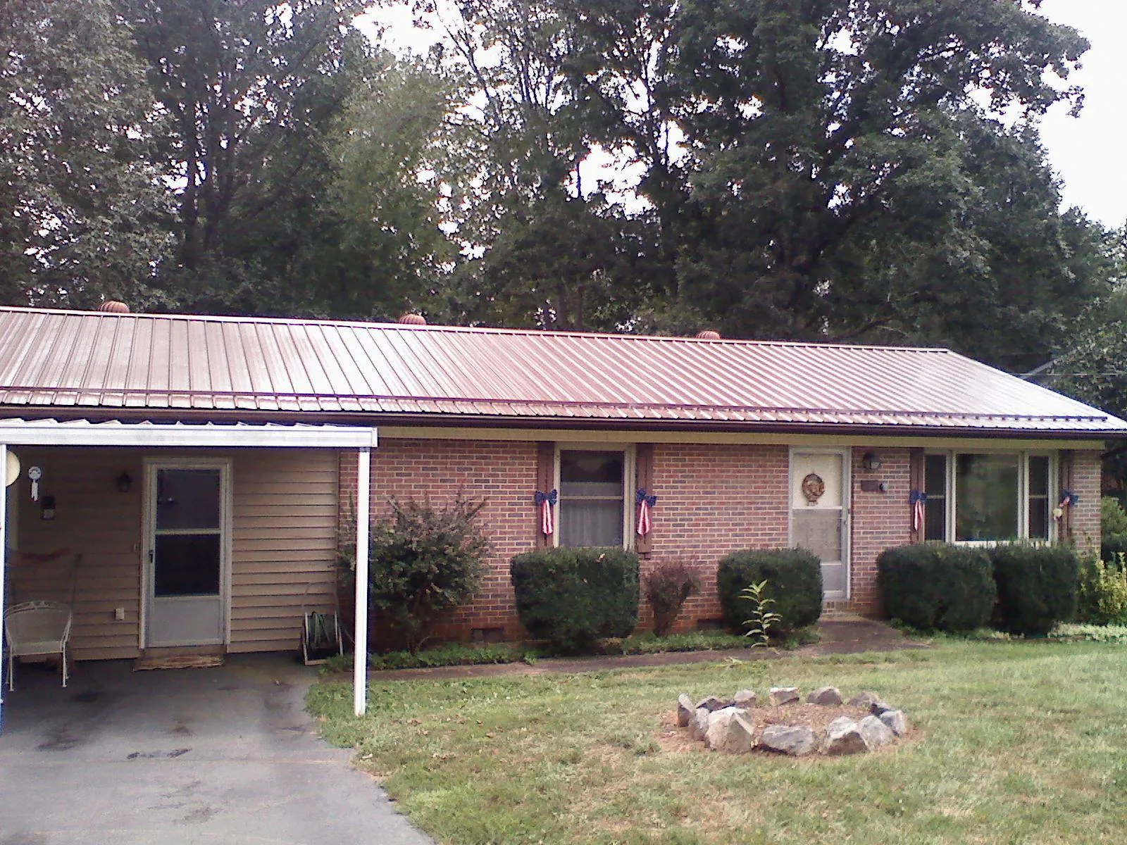 Bronze metal roof and carport on a brick ranch home — Roof Repair work by our crew in Uvalde