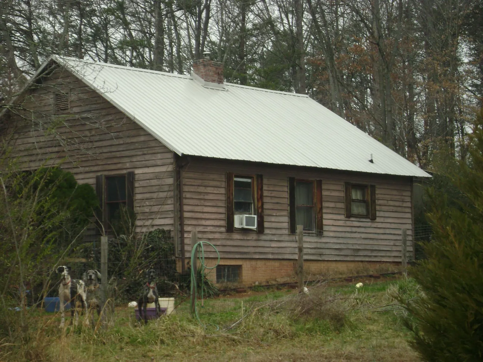 White metal roof on an old wood sided farmhouse, from a Metal Roof Installation job in Uvalde